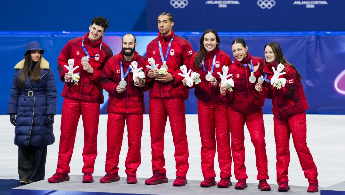 Les patineurs courte piste du relais mixte canadien sur le podium avec leurs médailles.