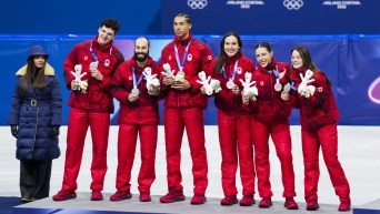 Les patineurs courte piste du relais mixte canadien sur le podium avec leurs médailles.