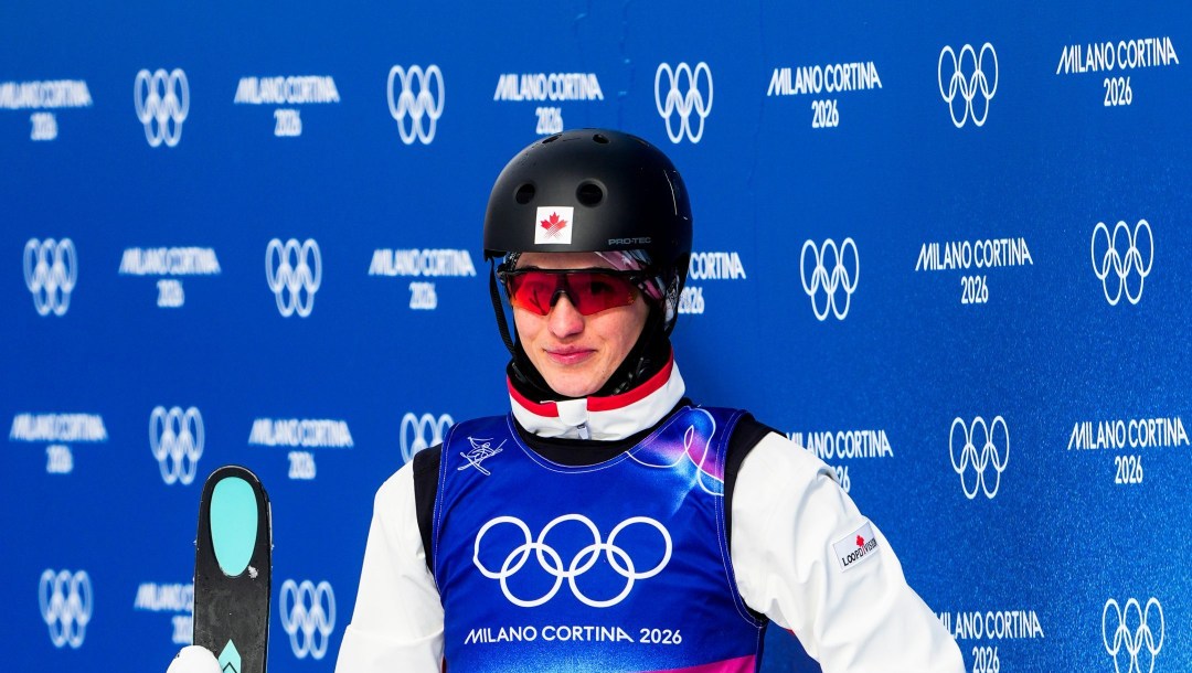Marion Thénault tient ses skis dans sa main au bas de la piste.