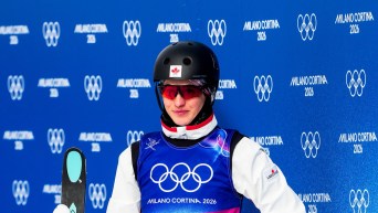 Marion Thénault tient ses skis dans sa main au bas de la piste.
