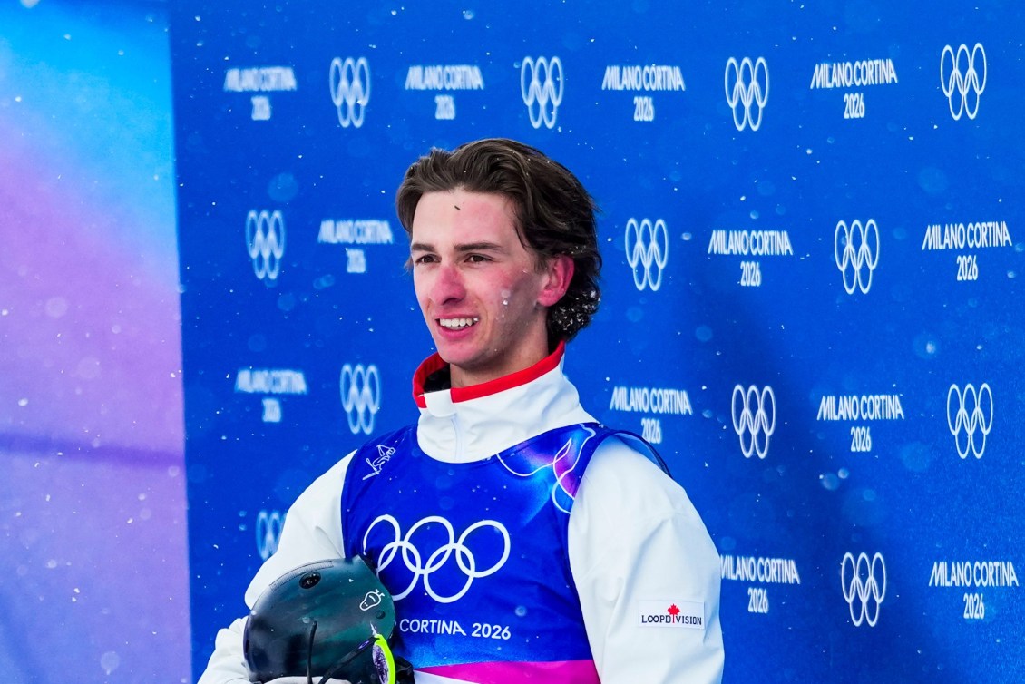 Émile Nadeau sourit avec son casque à la main. 
