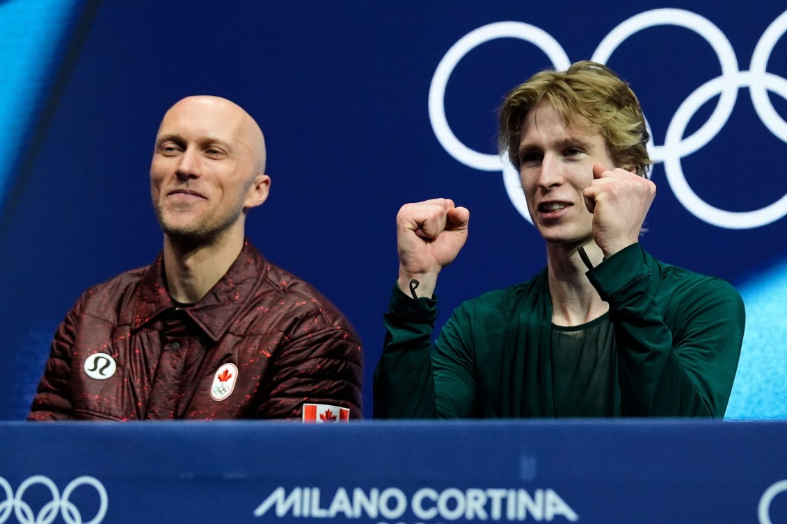 Stephen Gogolev du Canada, les poings en l'air, réagit positivement à ses scores après avoir participé au programme de patinage libre masculin